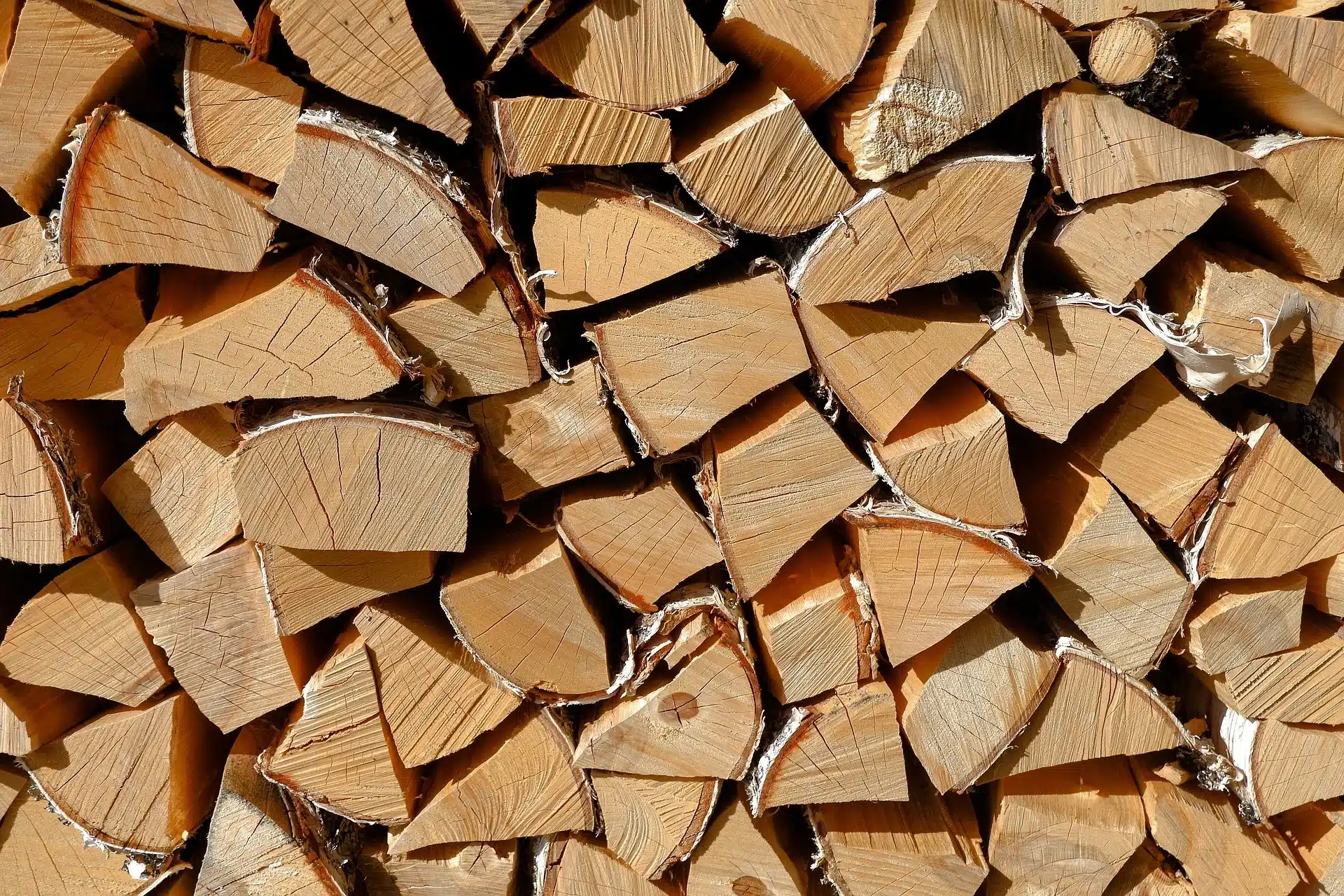 Ein dichter Stapel von trockenem Brennholz, bereit für den Einsatz als nachhaltige Energiequelle, illustriert im Blogartikel 